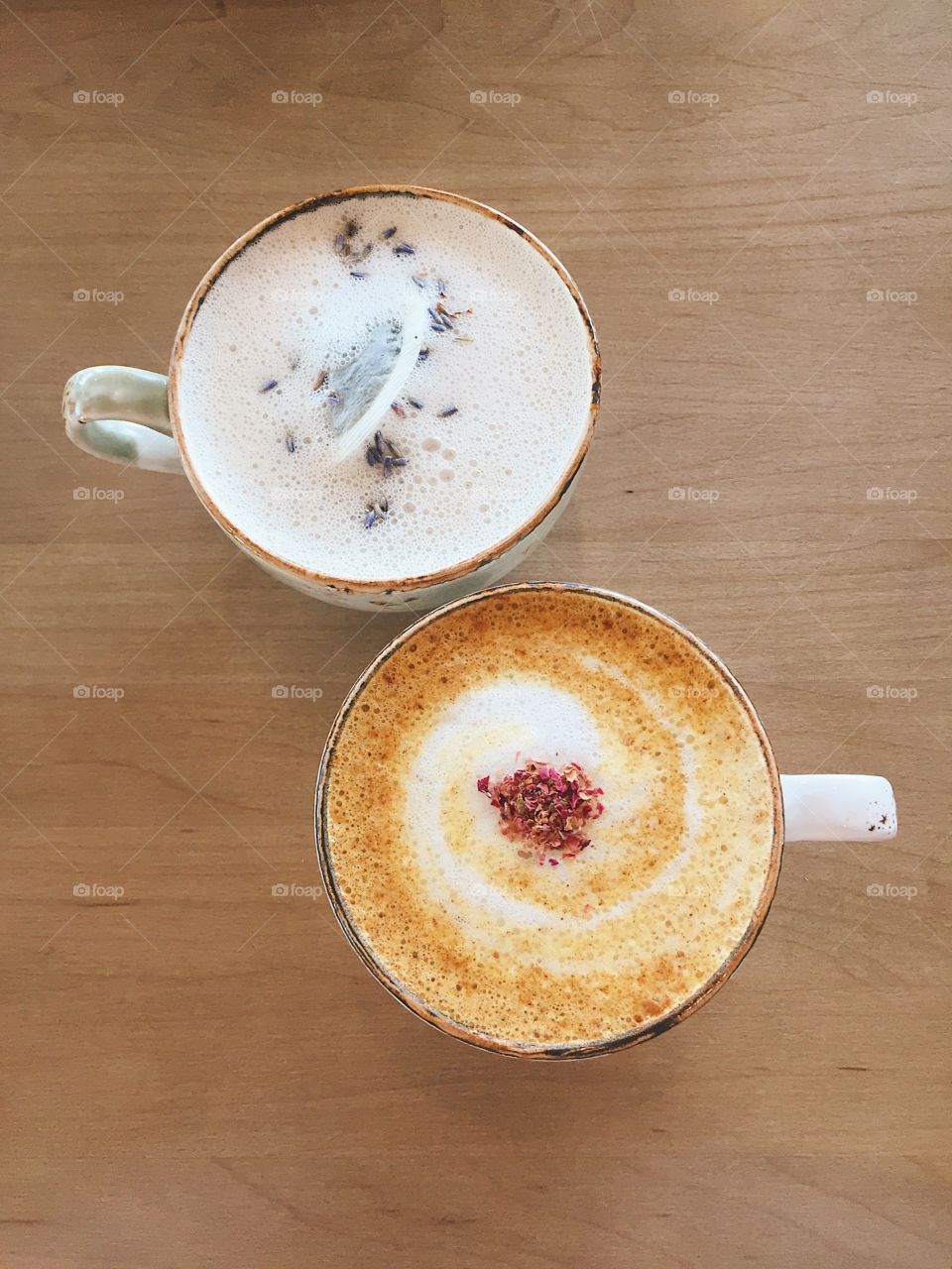 Two visually stunning warm drinks in an antique cup topped with warm milk foam and spices.