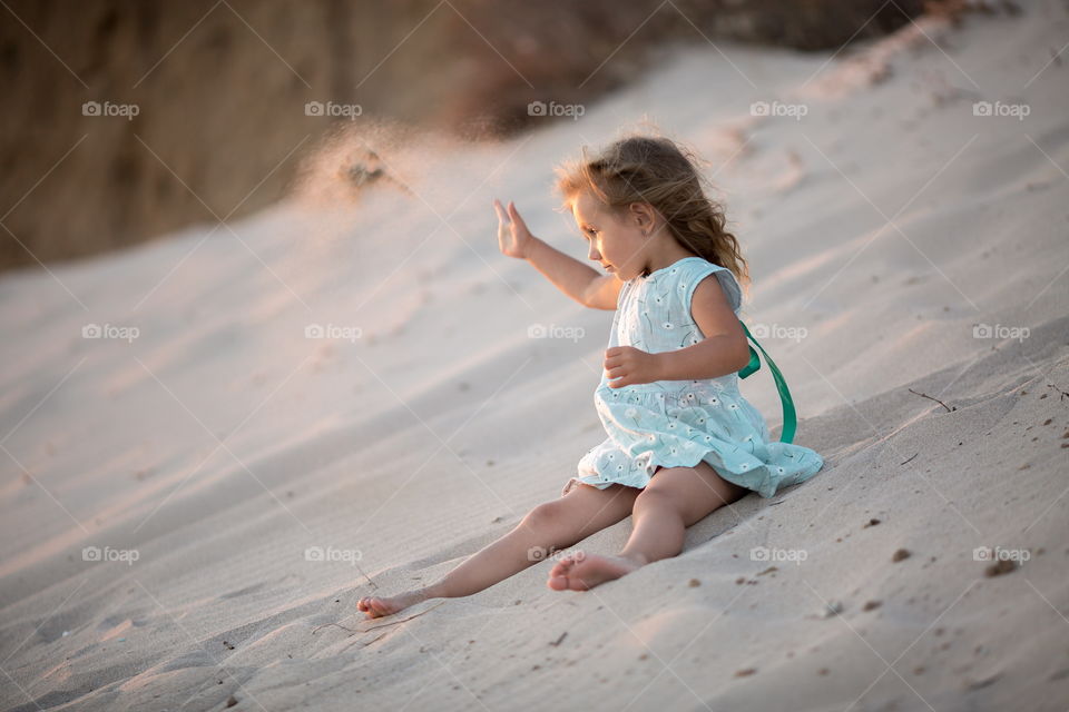 Little girl playing in the sand 