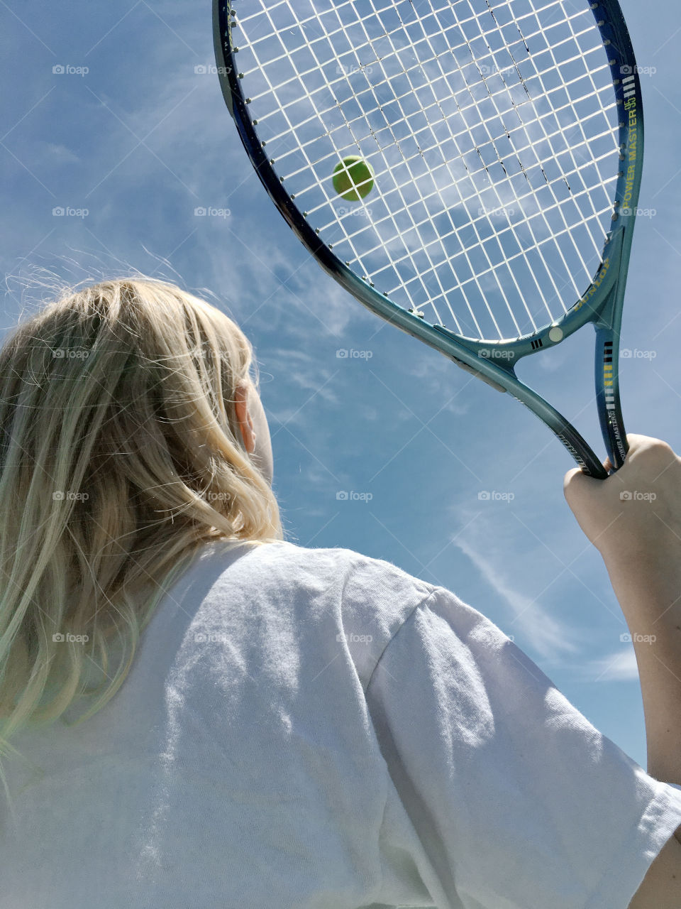 A tennis player mid-match on a sunny day 