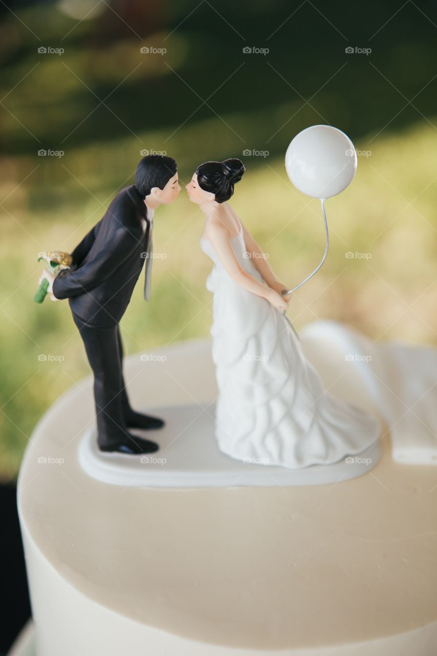 Cake topper of a newlywed couple kissing