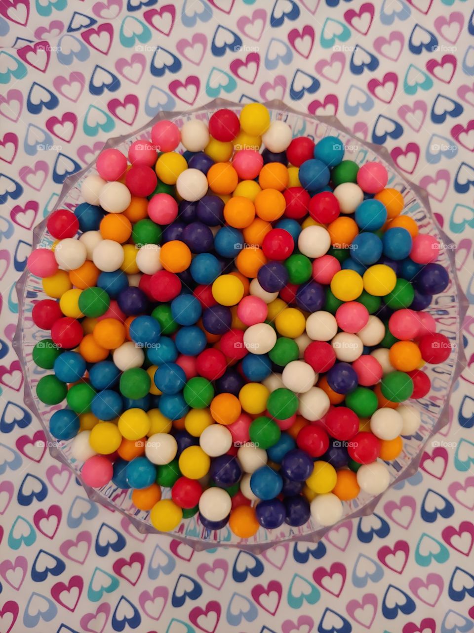 Rainbow Colored Gumballs in A Bowl surrounded by Hearts
