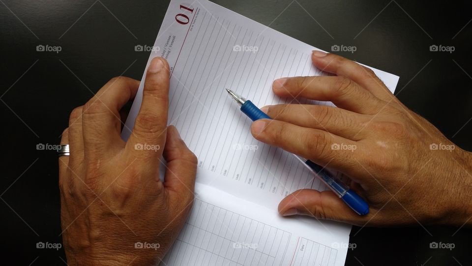 Background. Minhas mãos em ação sobre a mesa! Agenda (pagina em branco) e caneta. Escrevendo.