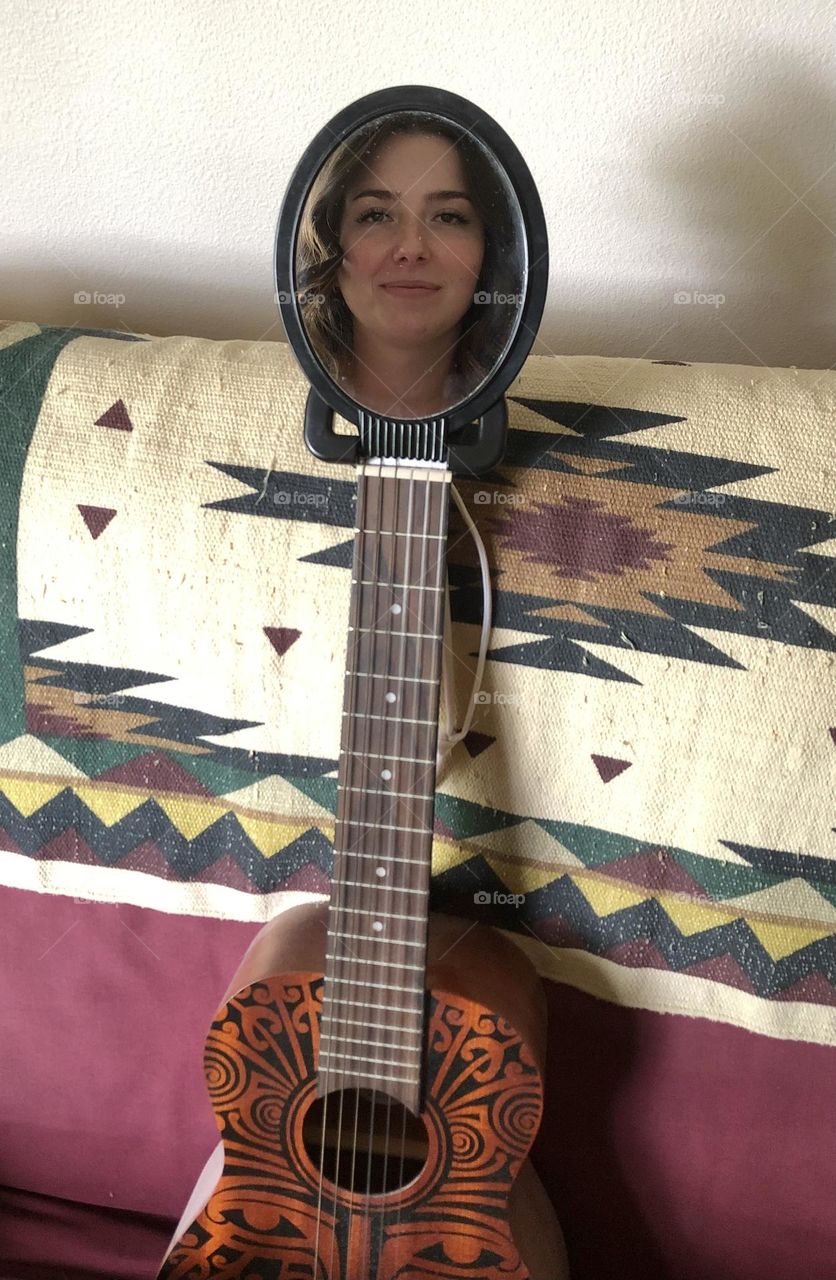 Young woman’s face on a guitar body