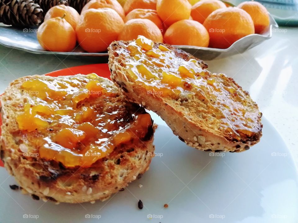 Homemade peach jam spread on whole grain dark rye bread