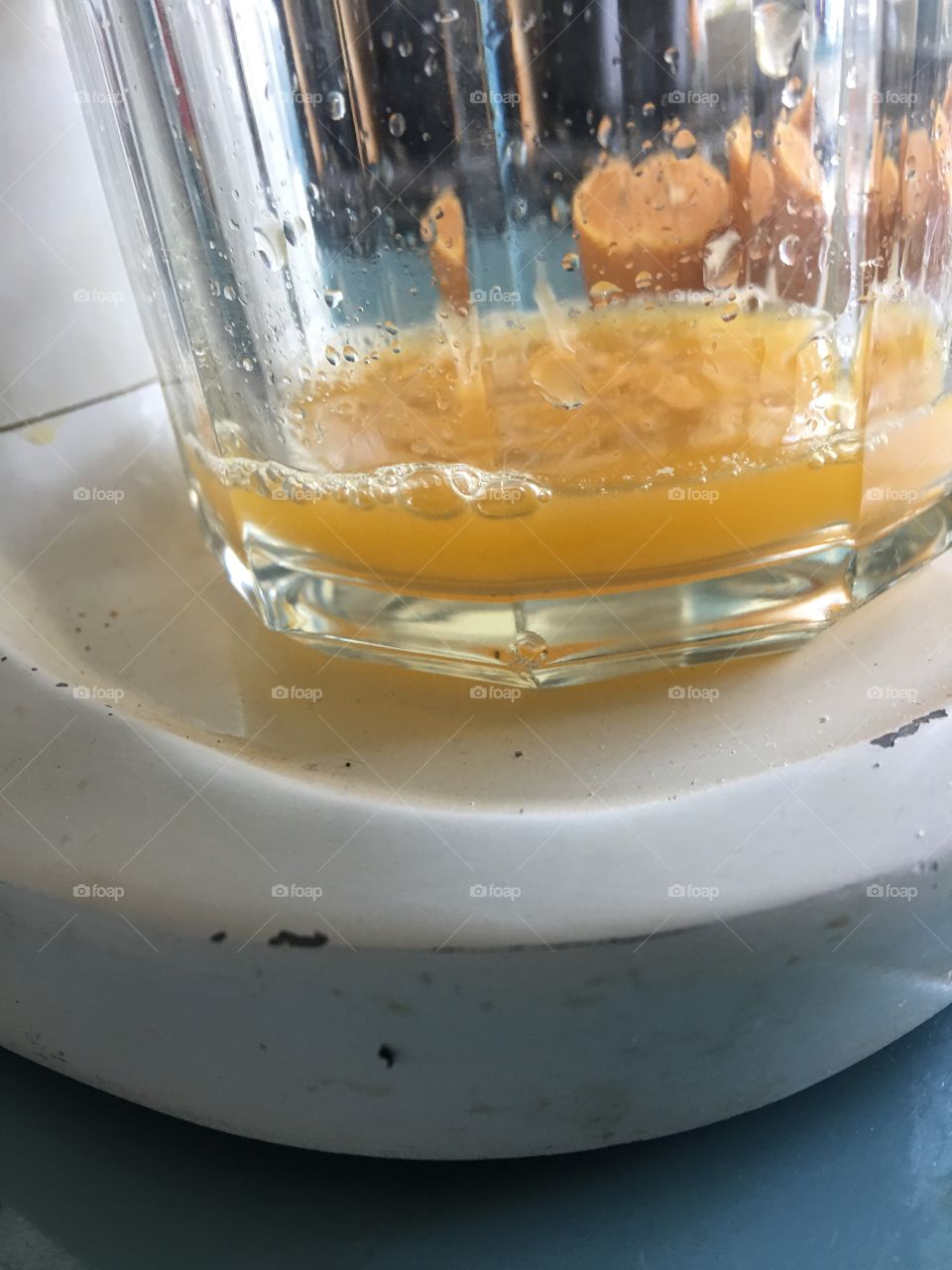 Fresh orange juice dripping into glass