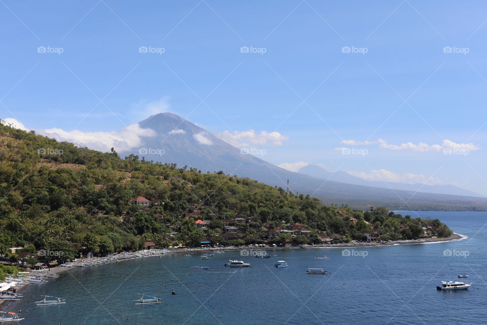 Mount Agung in Bali, Indonesia, with the Amed coast including the black sand beach of Jemeluk in the foreground
