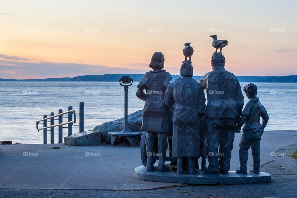 Supervising Sunset: A statue of whale watchers enjoying the best seat in the house for a beautiful sunset. 
