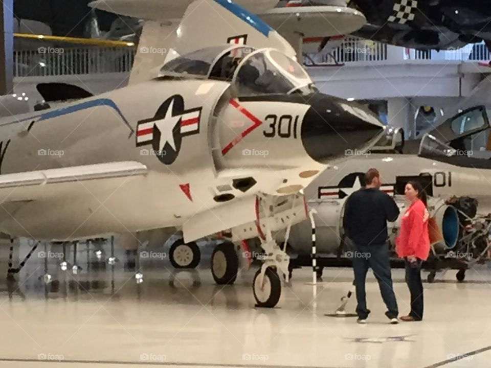 People looking at an airplane in a museum