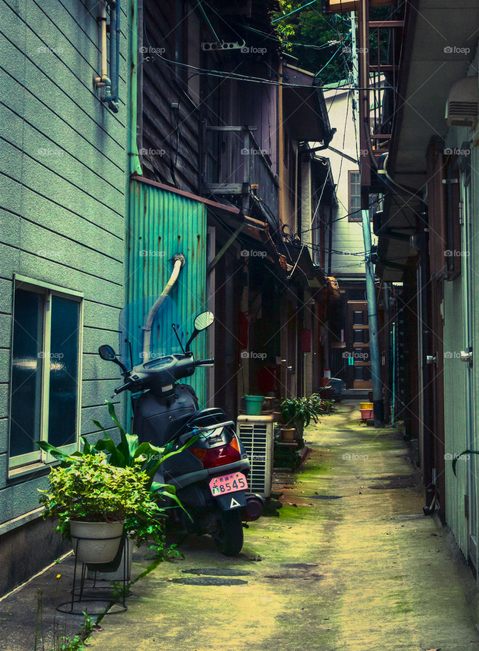 An alley with a scooter parked.