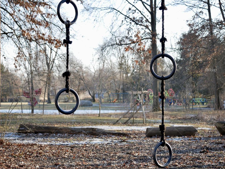 A children’s playground in winter. Climbing rings sit in the cold, waiting for kids to return. 