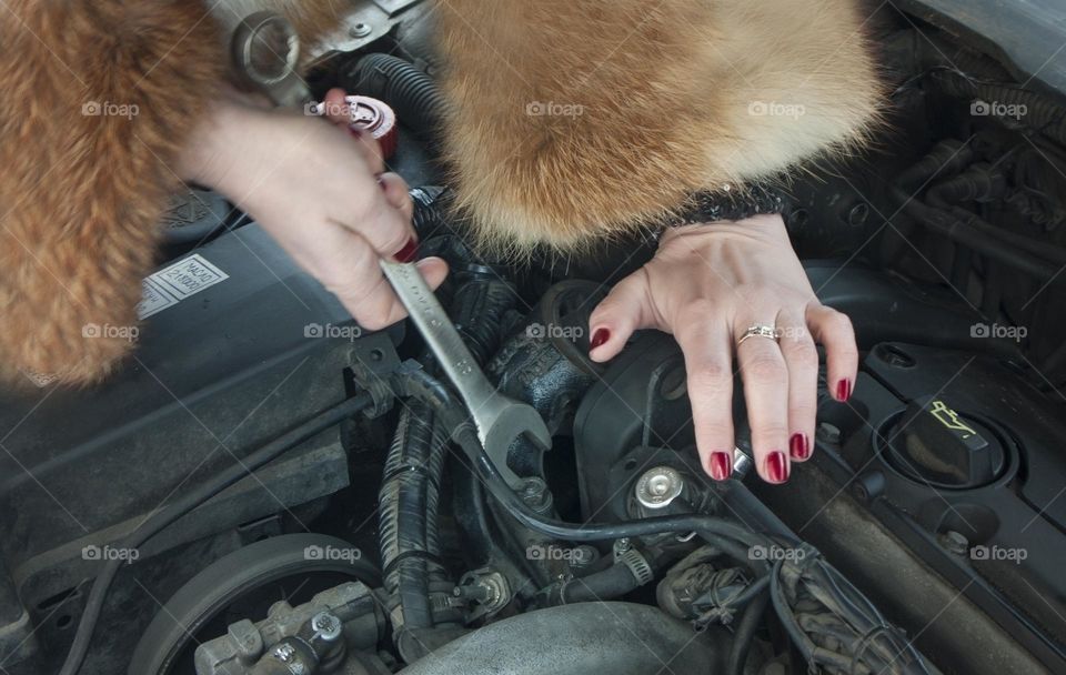 A woman repairing a car