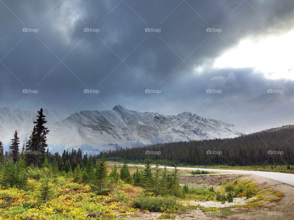 Storm cloud against snowy mountain