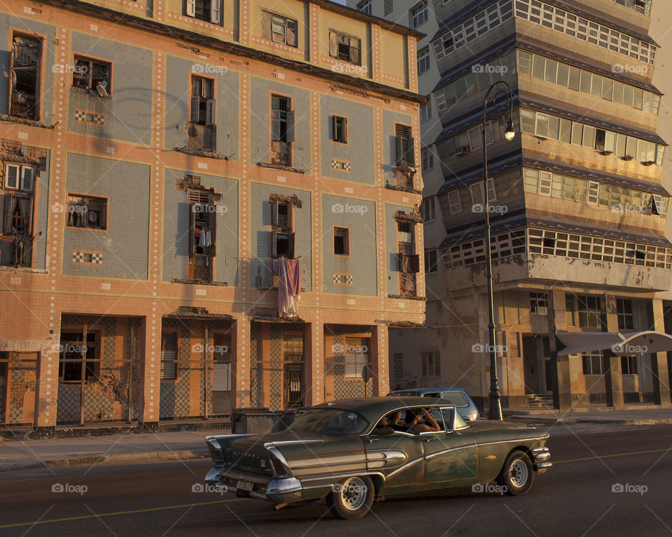 Antique car strolling the Malecón at sunset in Havana.
