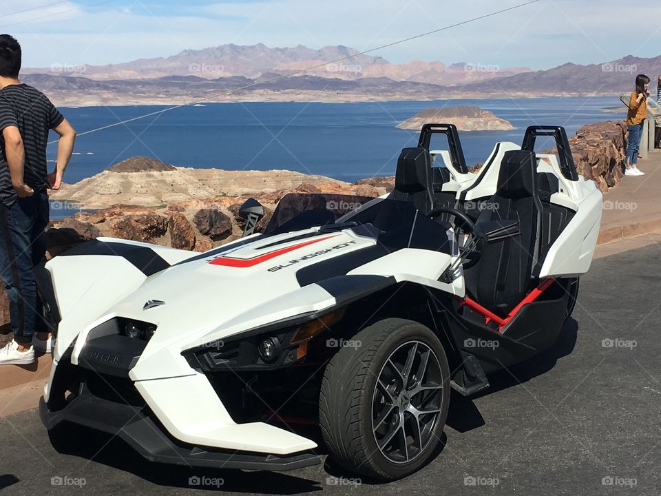 polaris slingshot sitting pretty in front of lake Meade near Las vegas on a sunny, hot day.  