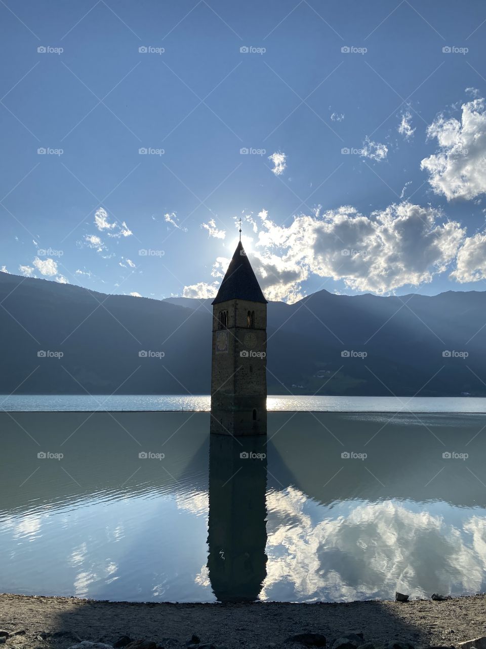 Magical reflections and lights surrounding this abandoned bell tower in Lake Curon, near Merano Italy