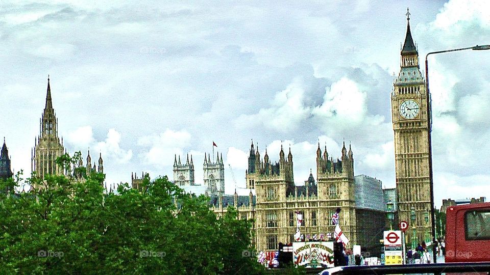 View of Big Ben and historic buildings in London with a red city bus