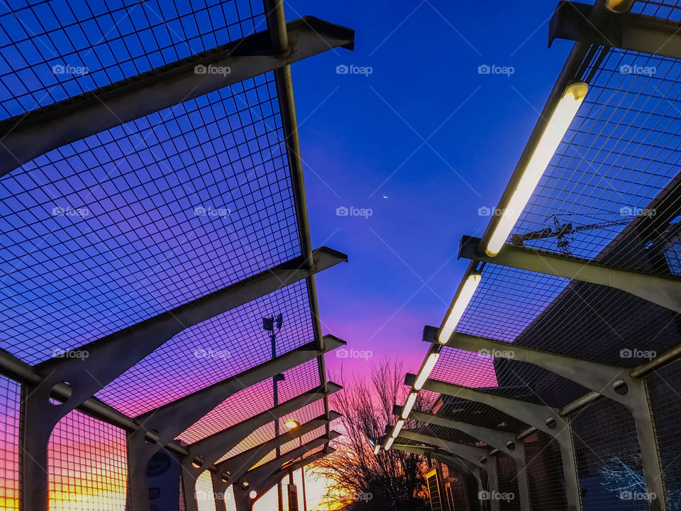 Sunset over pedestrian walkway with purple and pink sky