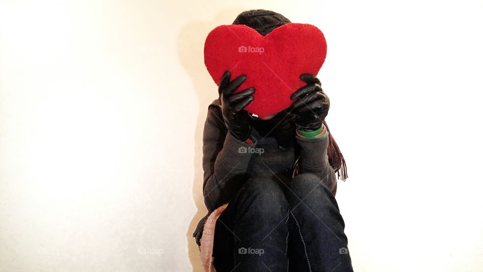 Woman holding a heart shaped plush toy.