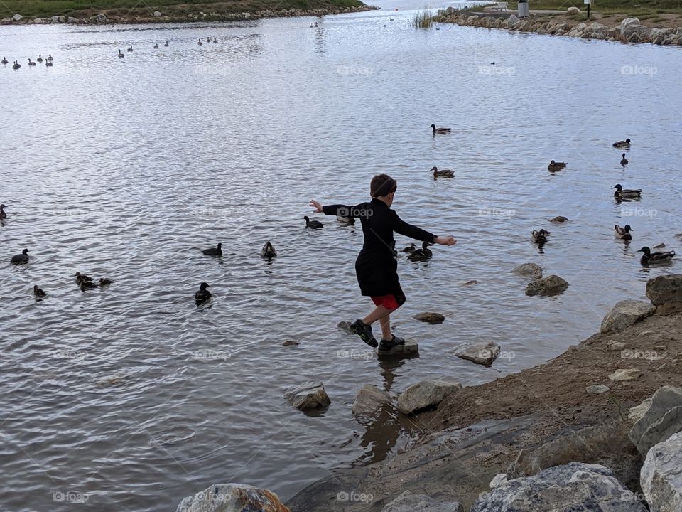 A Lake in Utah, a child balancing on rocks on the lake. ©️ Copyright CM Photography