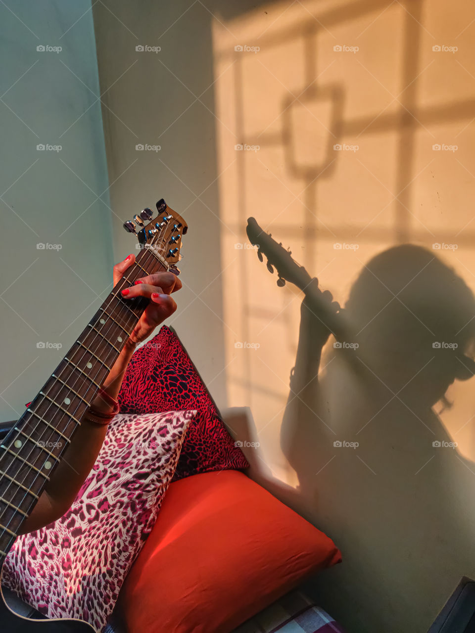 shadow of woman playing guitar at home sitting in the afternoon sunlight 🙂