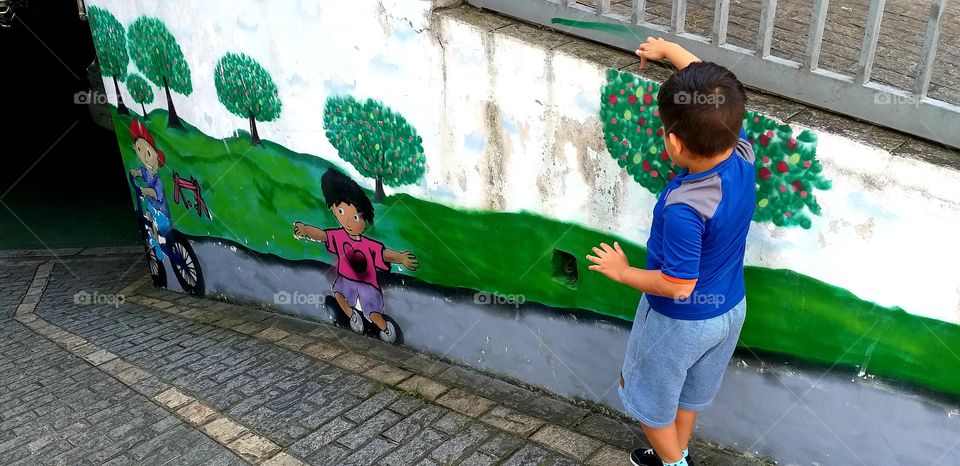 arte no muro com uma crianca brincando