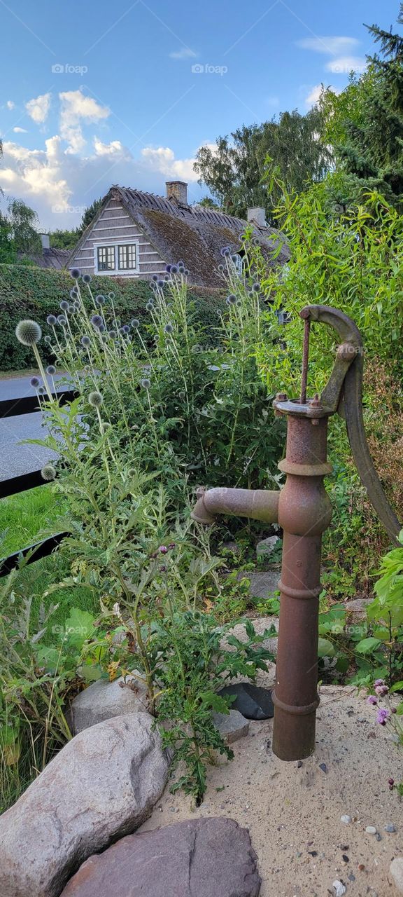 A water pump in foreground with atypical danish houses in background