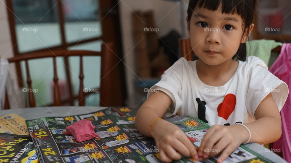 Asian girl sitting in kitchen