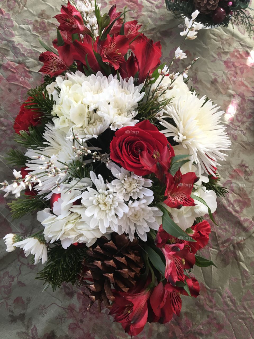 Cinnamon scented pinecones Christmas centerpiece red roses white pom-poms and alstroemeria