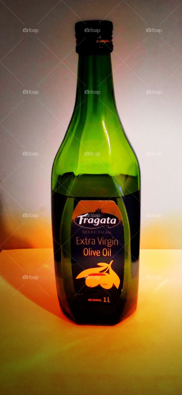 A bottle of a olive. A green colour olive bottle with a beautiful background.