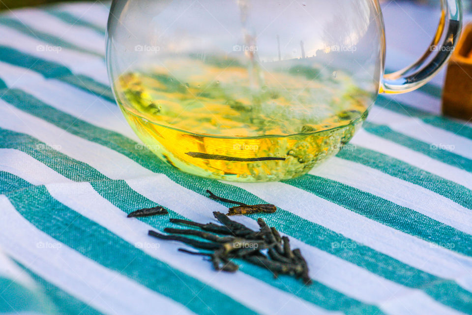 Green tea in jug and dry tea leaves