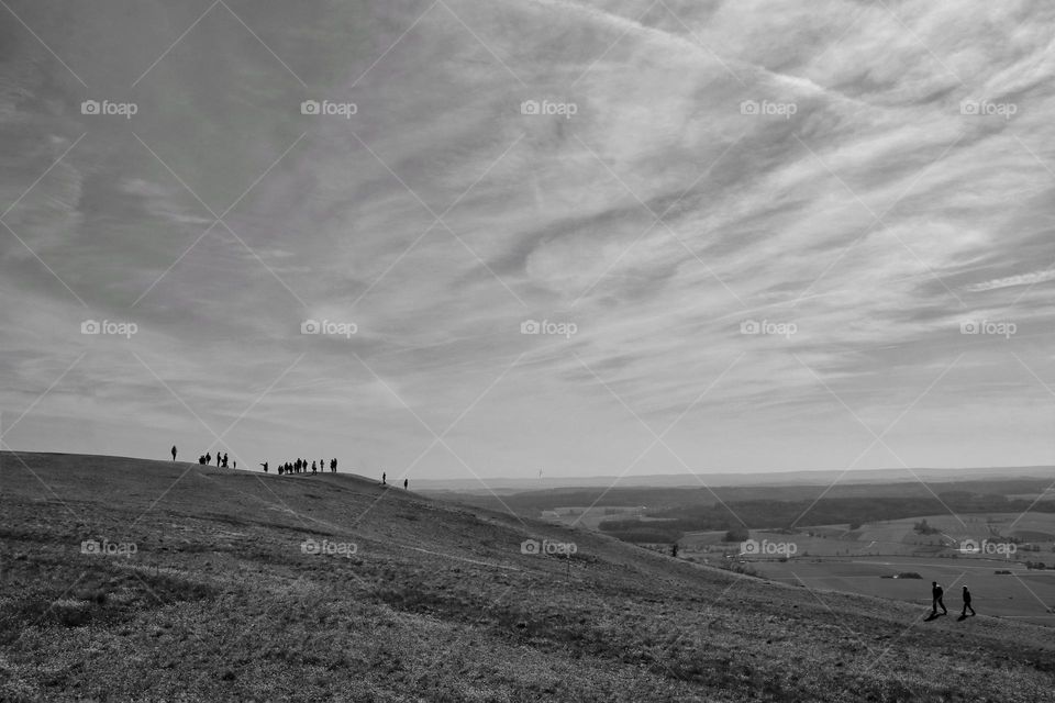 Landscape shot of wandering people on rolling hills and view in a valley 