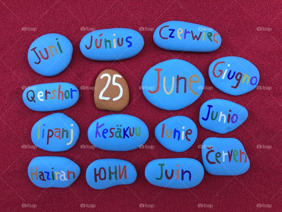 25 June, calendar date in many languages with colored stones and red background 