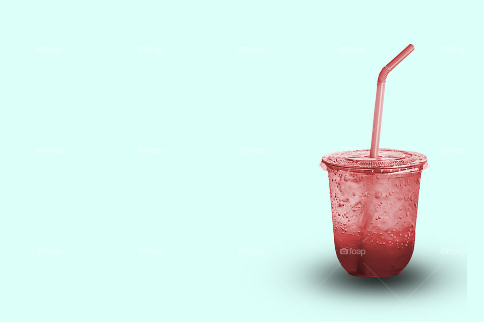 Red juice with ice in a plastic glass with clipping path.