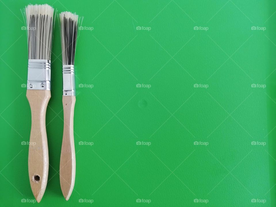 Paint brushes on a green background