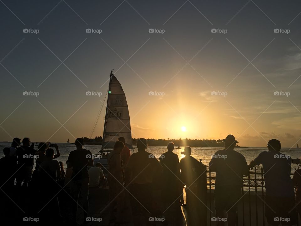 Sailboat passing the setting sun