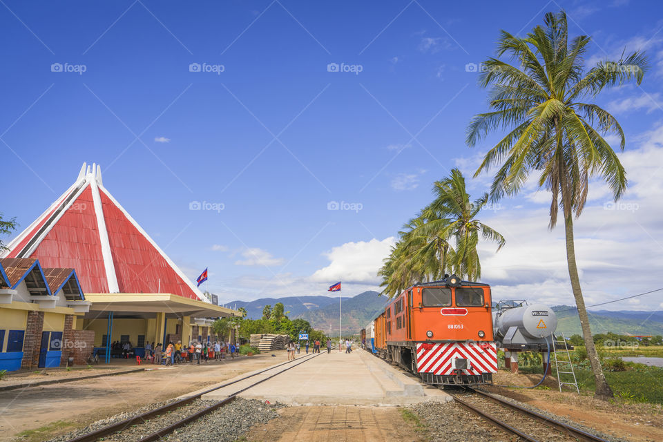 KOMPOT/CAMBODIA - February 04, 2017: Passenger cabin train arrives at Kampot train station with a beautiful blue sky and coconut tree stand in line