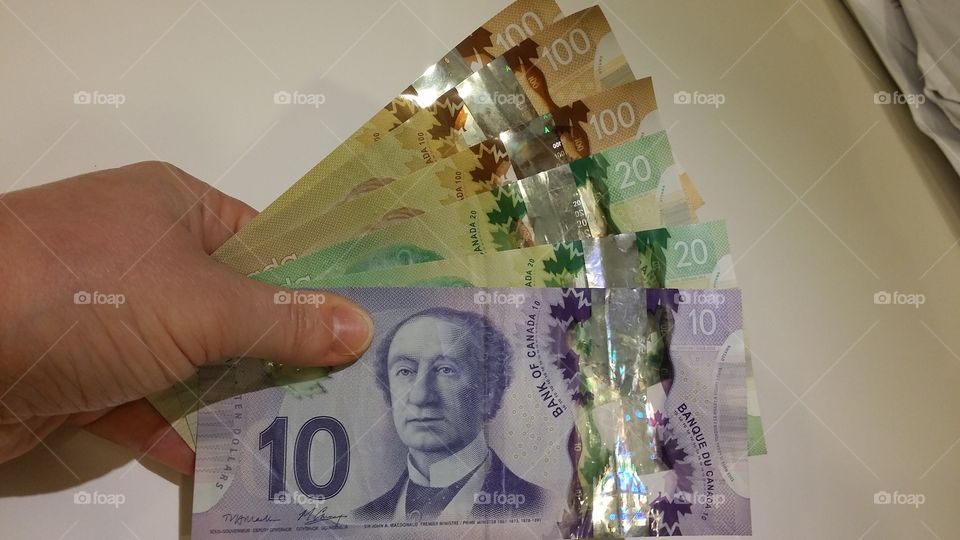 hand holding Canadian dollars