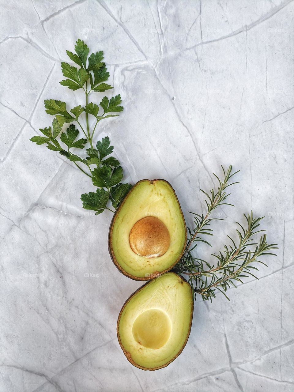 Green avocados at the table with herbs in summer season close up. Food background