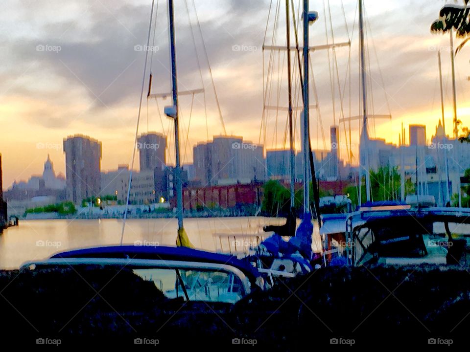 Boats in Newtown Creek Long Island City, Queens, New York in the late afternoon as the sun sets. This picture was taken in the Spring of 2019. In the background in the far distance you can see the Manhattan skyline. Hypnotic Productions