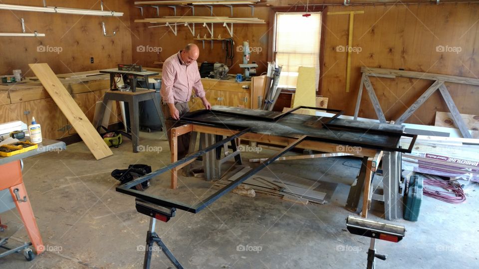A craftsman working on a wood work project in the shop
