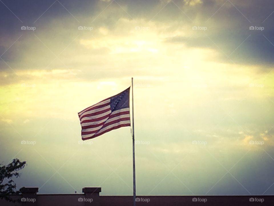 Freedom flies. US flag flies over city in beautiful sky