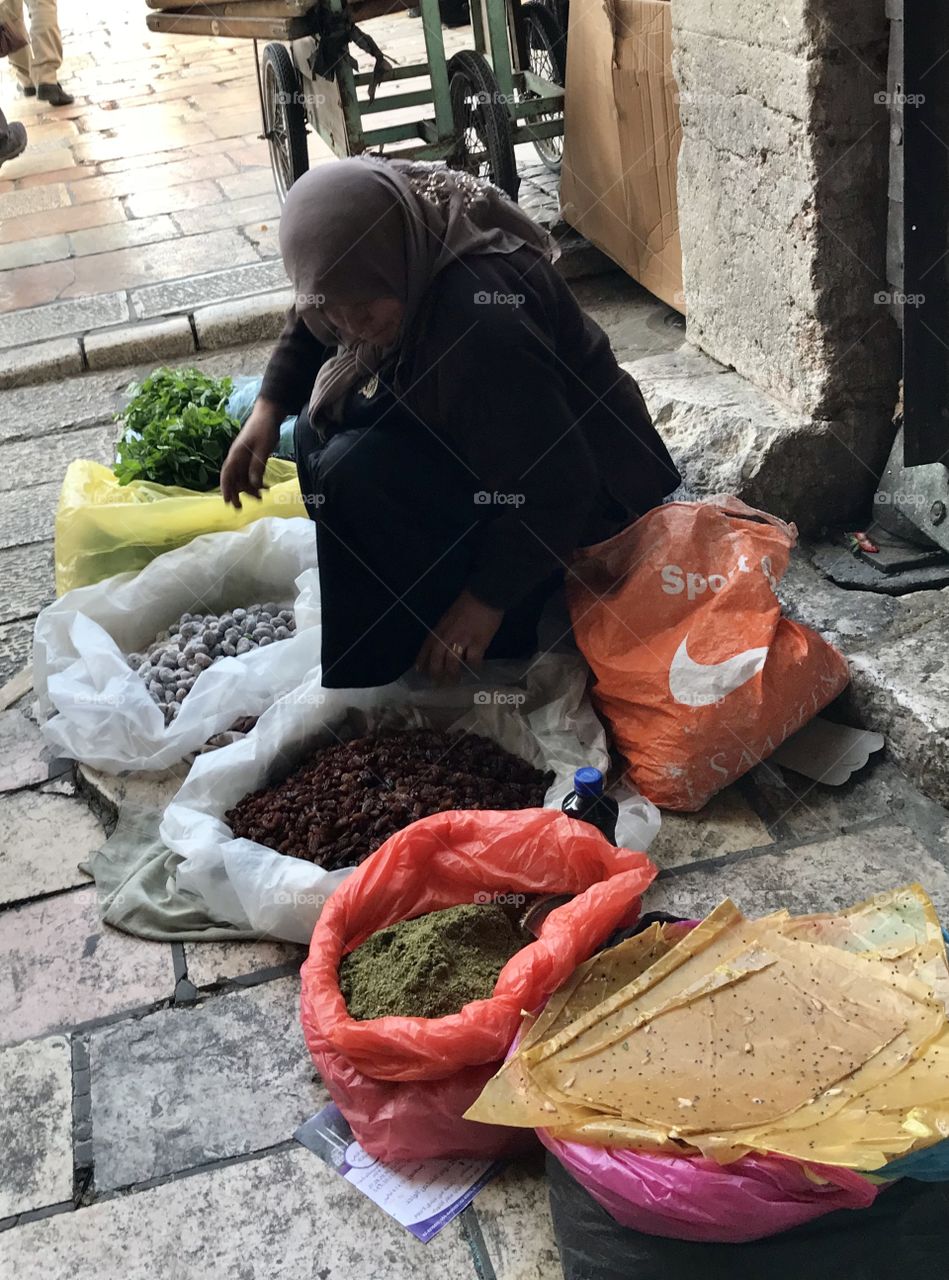 An old woman selling spices in the market, Muslim Quarter, Old City Jerusalem, Israel. 