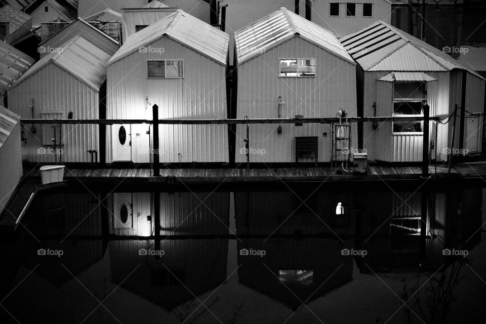 The reflection of storage units on the water are illuminated by light near the Tacoma Yacht Club, Tacoma, Washington 