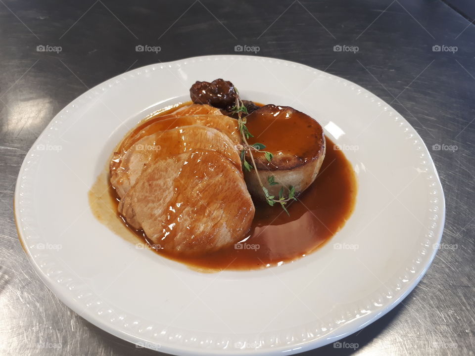 a delicious roasted slice of beef with a fondant potato glazed with homemade gravy