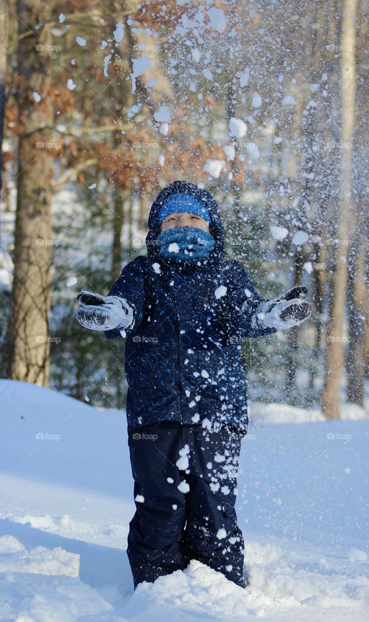 Playing in the snow in a blue snowsuit