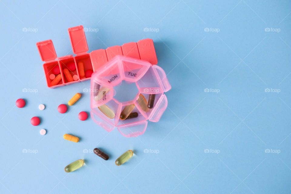 Pink pill boxes with medicines on the blu background 