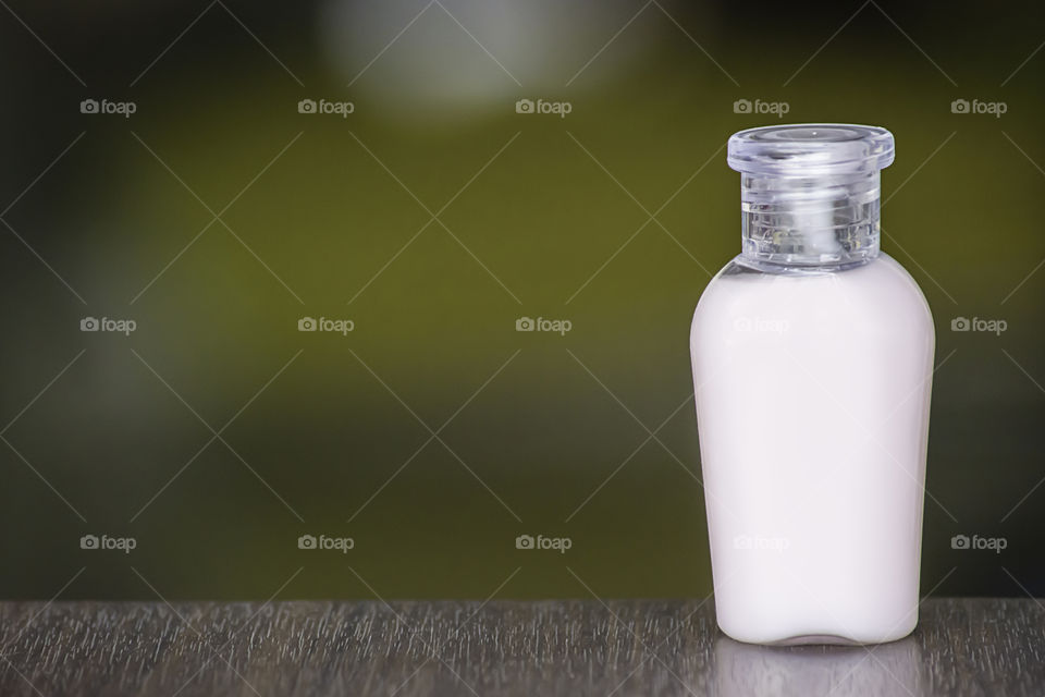 Small bottle shower gel on a wooden table The background blurry.