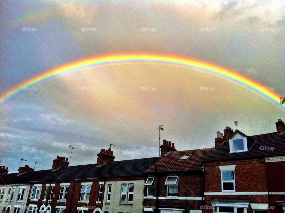 Amazing bright rainbow over rooftops