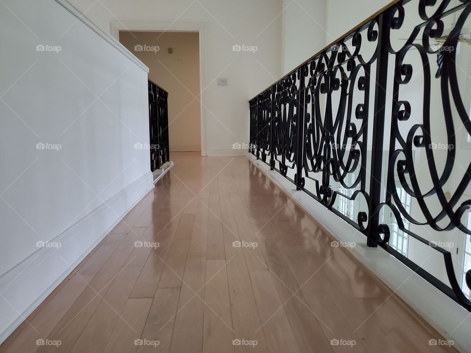 Hallway with wrought iron handrails and white wall