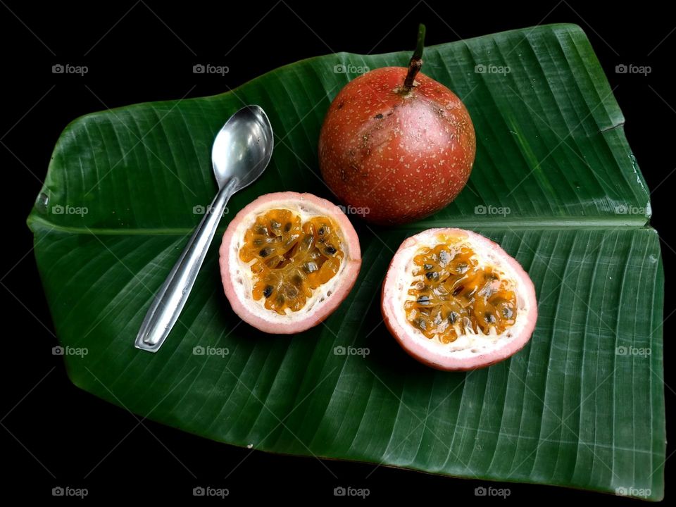 Natural passion fruit on a leaf with a spoon, ready to eat